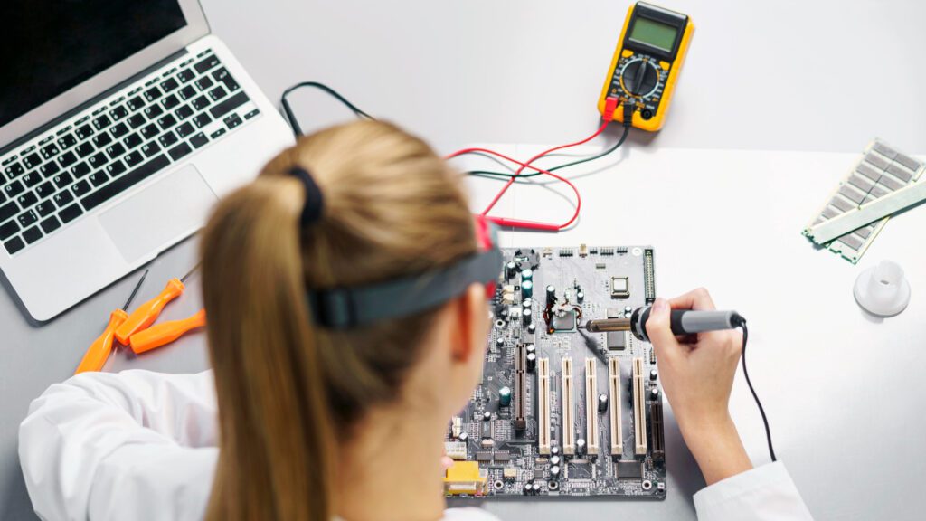 high angle female technician with soldering iron electronics motherboard 1